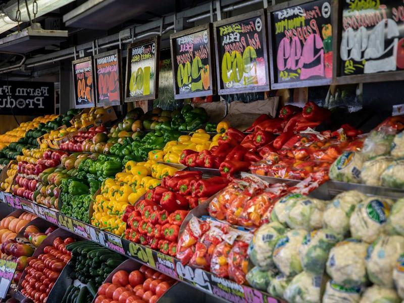 colorful vegetables in bins with price signs above